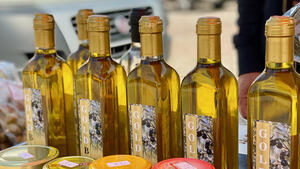 Mehrere Flaschen mit Olivenl stehen auf einem Verkaufstresen.