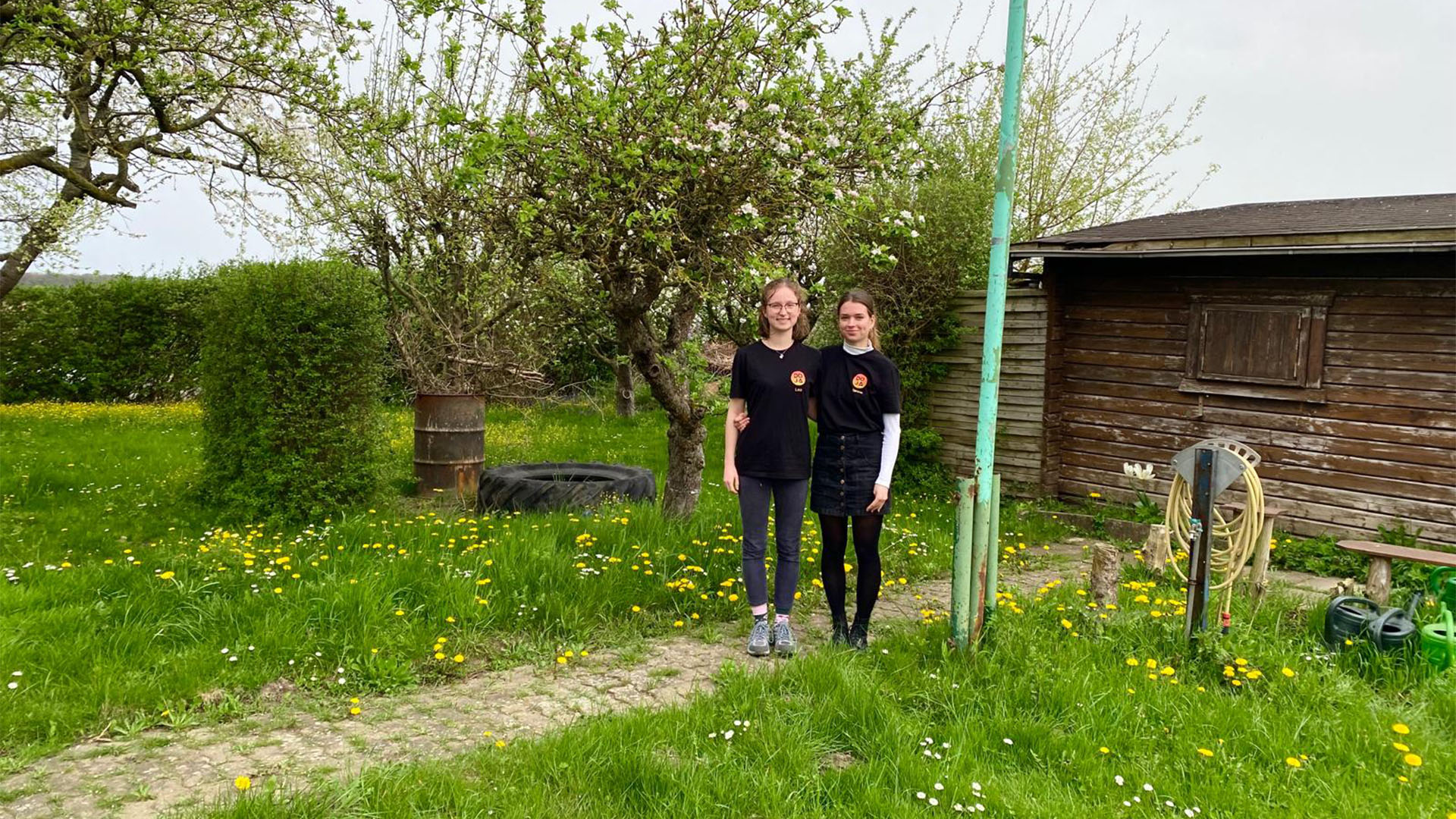 Zwei junge Frauen stehen in einer Gartenparzelle..