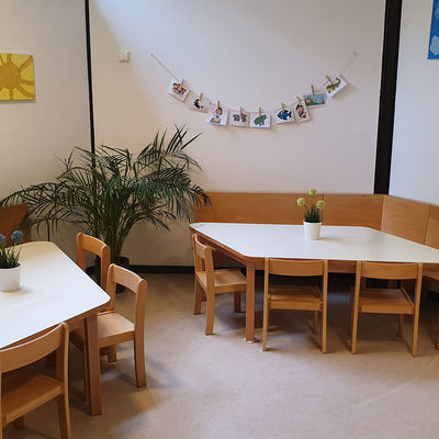 Blick in die Cafeteria der Kita Geibelstraße mit Tischen und Stühlen.