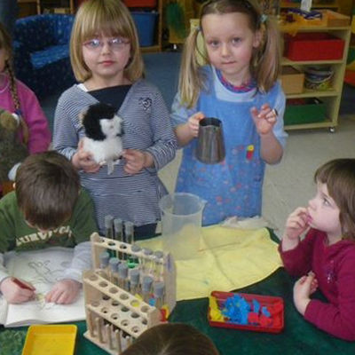 Kinder experimentieren im Kindergarten Ahlum: Farbiges Wasser wird gemischt und beobachtet.