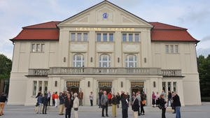 Viele Personen stehen auf dem Platz vor dem Lessingtheater.