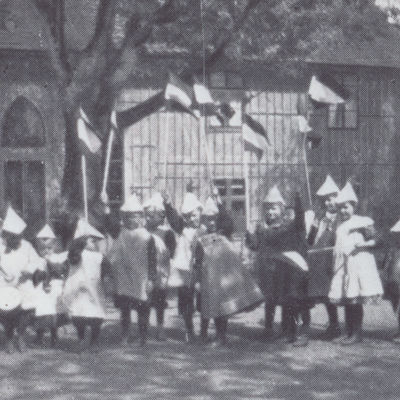 historisches Schwarzweißfoto von Kindern des Henriette Breymann Kindergarten vor dem Kindergartengebäude