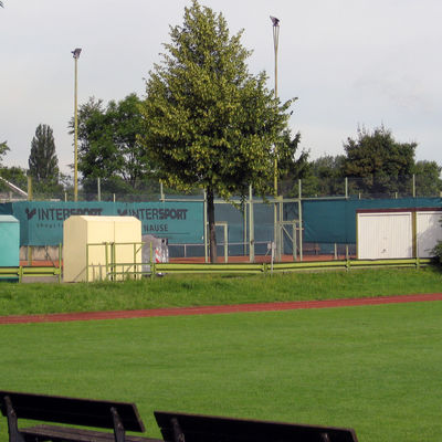 Blick über einen Rasenplatz und Tartanbahn auf den Tennisplatz des TSV Leinde