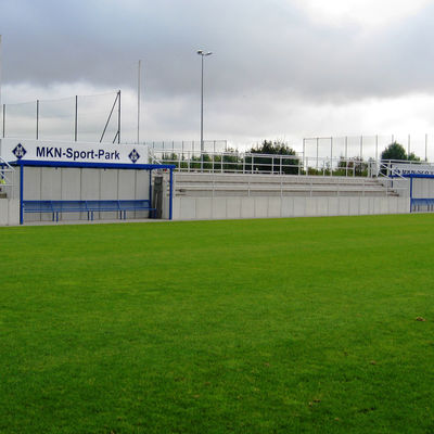 Rasenfläche des BV Germania, A-Platz, im Hintergrund Tribünen und das Schild MKN-Sport-Park