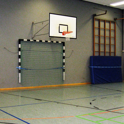 Innenansicht der Sporthalle Salzdahlum mit Blick auf die Wand mit Basketballkorb und Handballtor