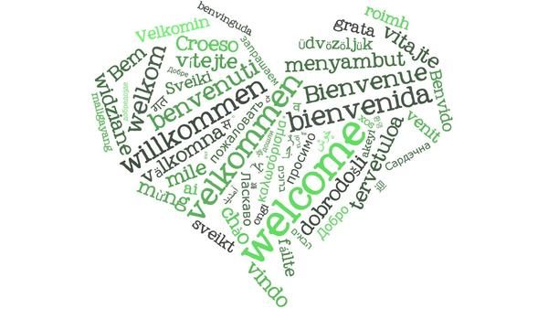 Unterschiedliche Begrüßungsformeln beziehungsweise Begrüßungsworte in grüner Schrift und in verschiedenen Sprachen sind zu einem Herz geformt.