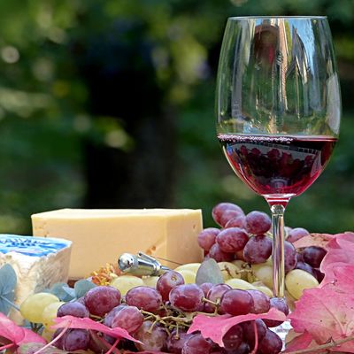 Eine Weinflasche mit gefülltem Glas, Weintrauben und Käse.