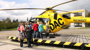 Vor einem gelben Hubschrauber der ADAC-Luftrettung stehen viele Kinder und einige Erwachsene.