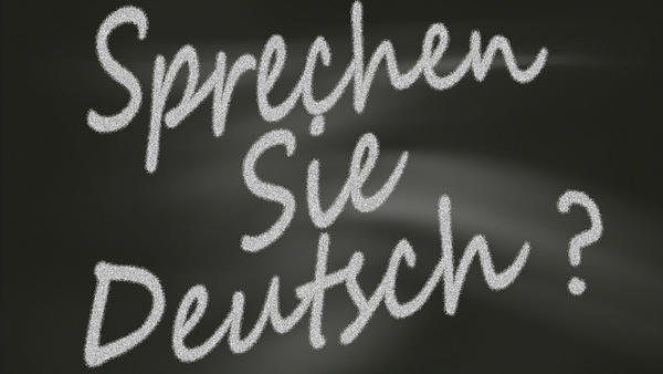Kreidetafel mit der weißen Aufschrift "Sprechen Sie Deutsch?".