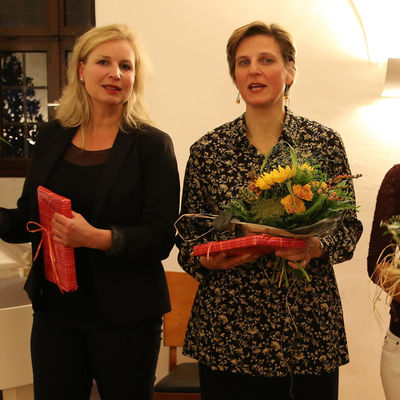 Friederike Kannenberg, Katrin Hildebrandt und Susanne Maierhöfer stehen nebeneinander mit Blumen und Präsenten in den Händen.