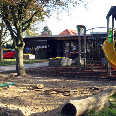 Klettergerüst und Sandplatz an einer Kindertagesstätte.