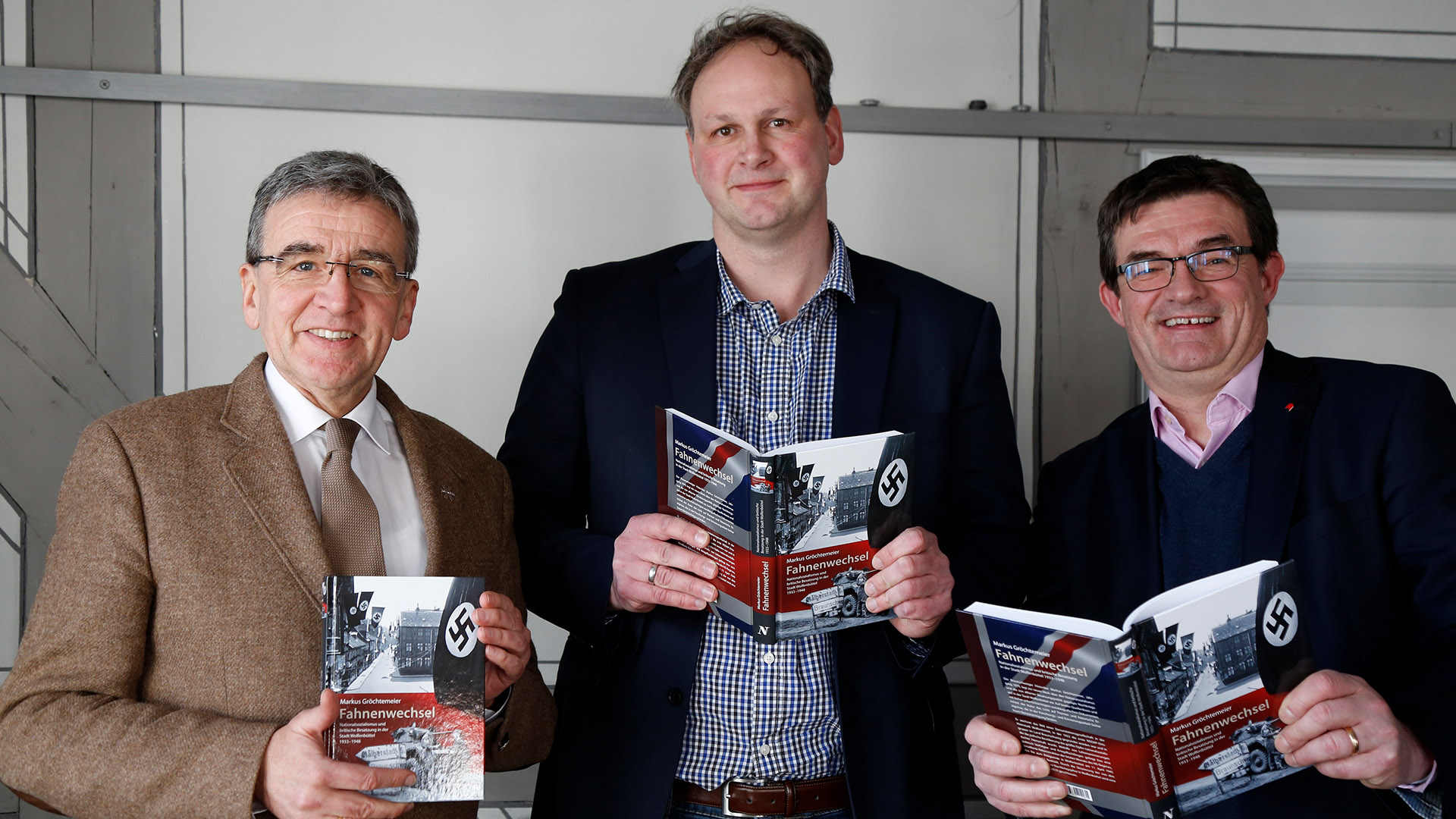 Das Foto zeigt drei Personen: Wolfenbüttels Bürgermeister Thomas Pink, Autor Markus Gröchtemeier und Verleger Carsten Holzendorff. Sie alle halten das Buch mit dem Titel »Fahnenwechsel« in die Kamera.
