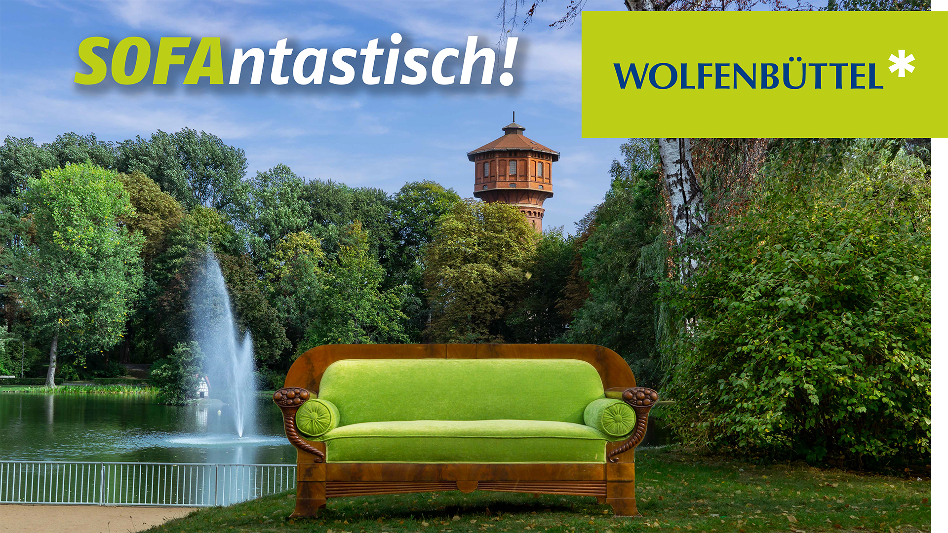 Ein Sofa steht auf einer Grünfläche vor der Fontäne des Stadtgrabens. Im Hintergrund sind Bäume und der Wasserturm Wolfenbüttels zu erkennen. Das Plakatmotiv wird ergänzt durch die Schriftzüge "Wolfenbüttel" und "Sofantastisch!"