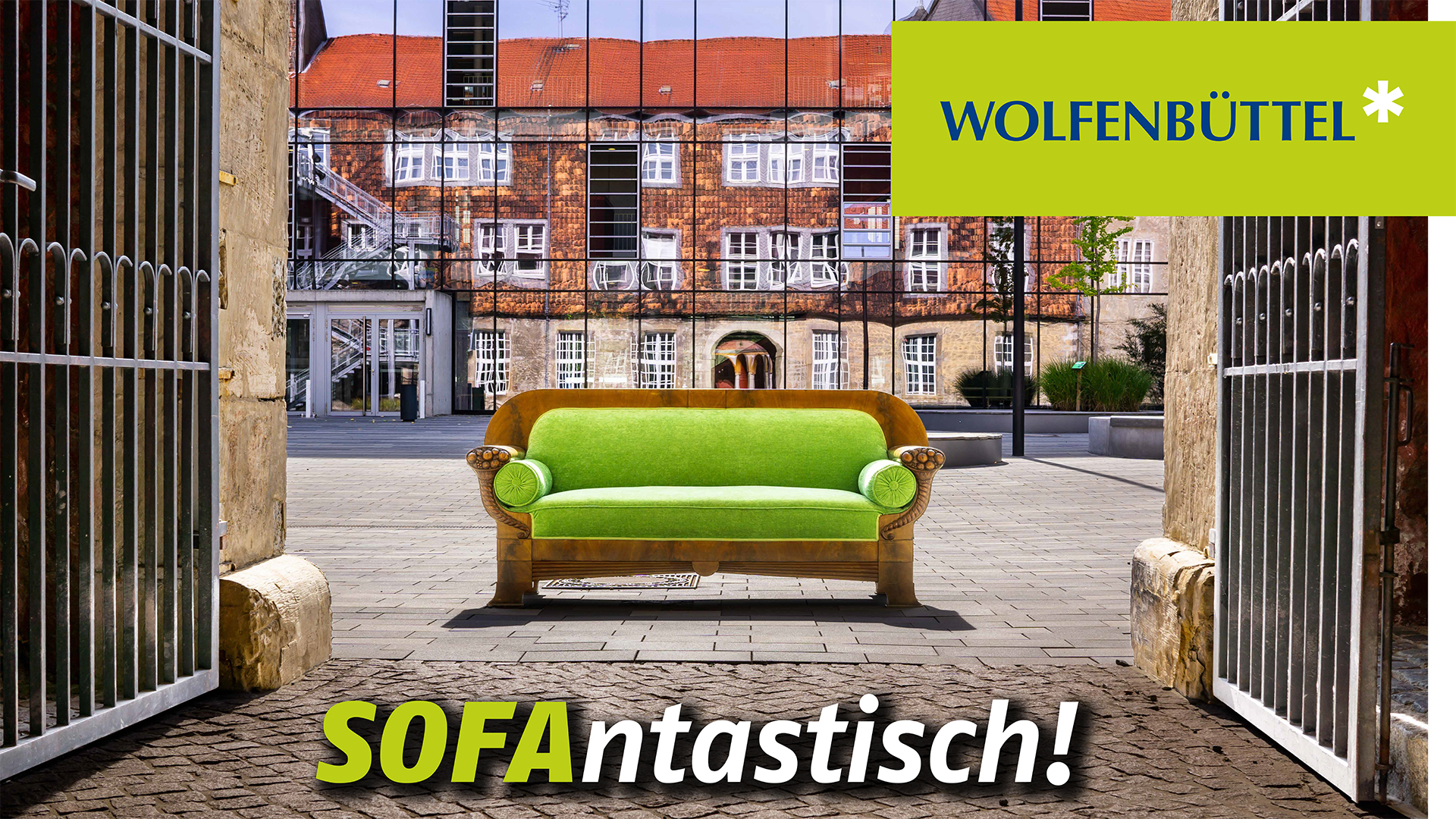 Ein Sofa steht vor einem Gebäude mit spiegelnder Glasfassade. Das Plakatmotiv wird ergänzt durch die Schriftzüge "Wolfenbüttel" und "Sofantastisch!"
