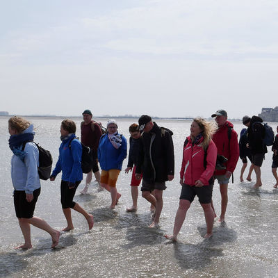 Eine Gruppe von Personen wandert am Strand.