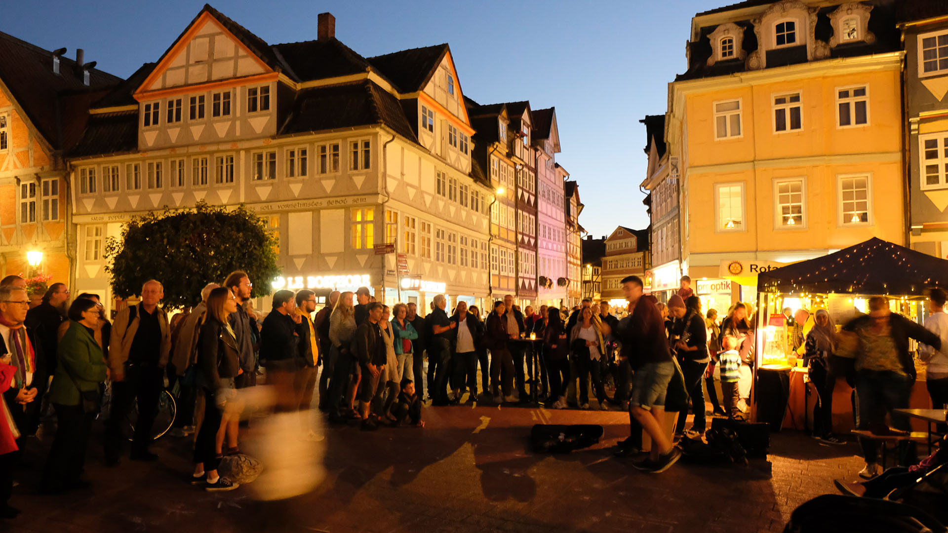 Fußgängerzone der Stadt Wolfenbüttel mit einigen Besucherinnen und Besuchern in der Abenddämmerung.