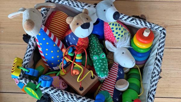 Eine Kiste mit verschiedenen Kuscheltieren und Spielzeug.