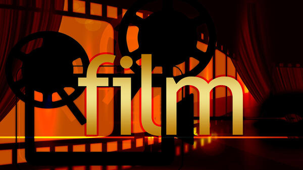 Symbolbild: Hinter dem Wort film sind Filmrollen auf orangenem Hintergrund zu erkennen.