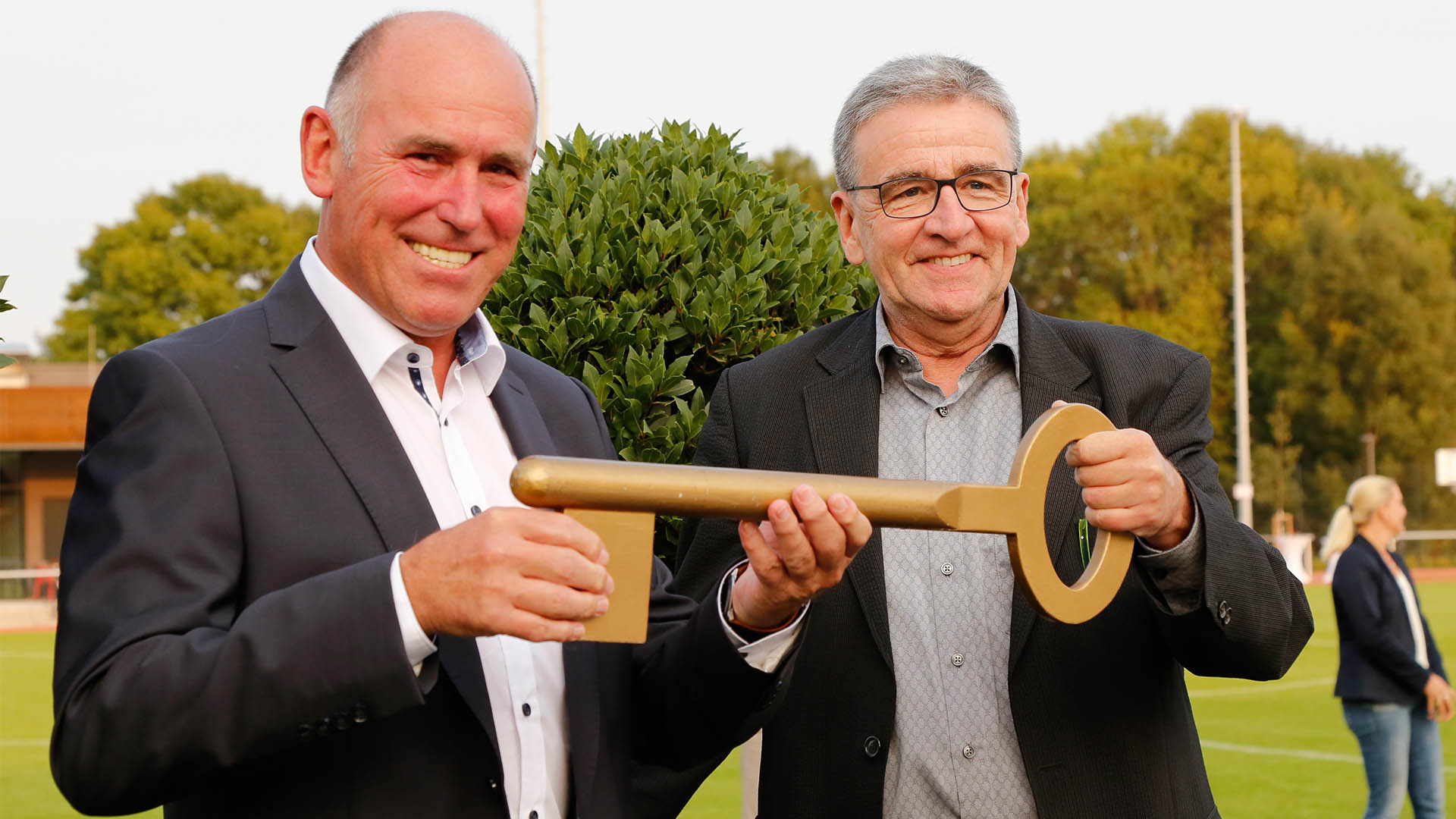 Klaus Dünwald und Thomas Pink halten einen übergroßen Schlüssel in den Händen.