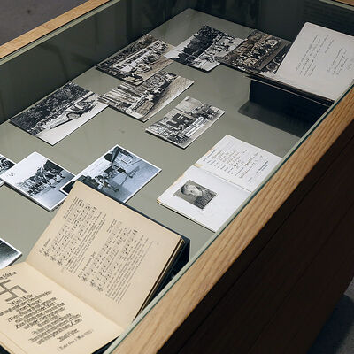 Zu sehen sind Fotos und Dokumente in einer Museums-Vitrine. Diese beinhaltet unter Glas die Exponate zur Zeit des Nationalsozialismus.