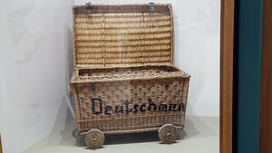 Das Foto zeigt die Großvitrine des Bürger Museums. In ihr steht neu ein großer Bastwagen mit vier Rädern. Es ist ein originaler Handwagen, mit dem Marie Deutschmann als Vertriebene 1946 aus Schlesien über Freital nach Wolfenbüttel kam.