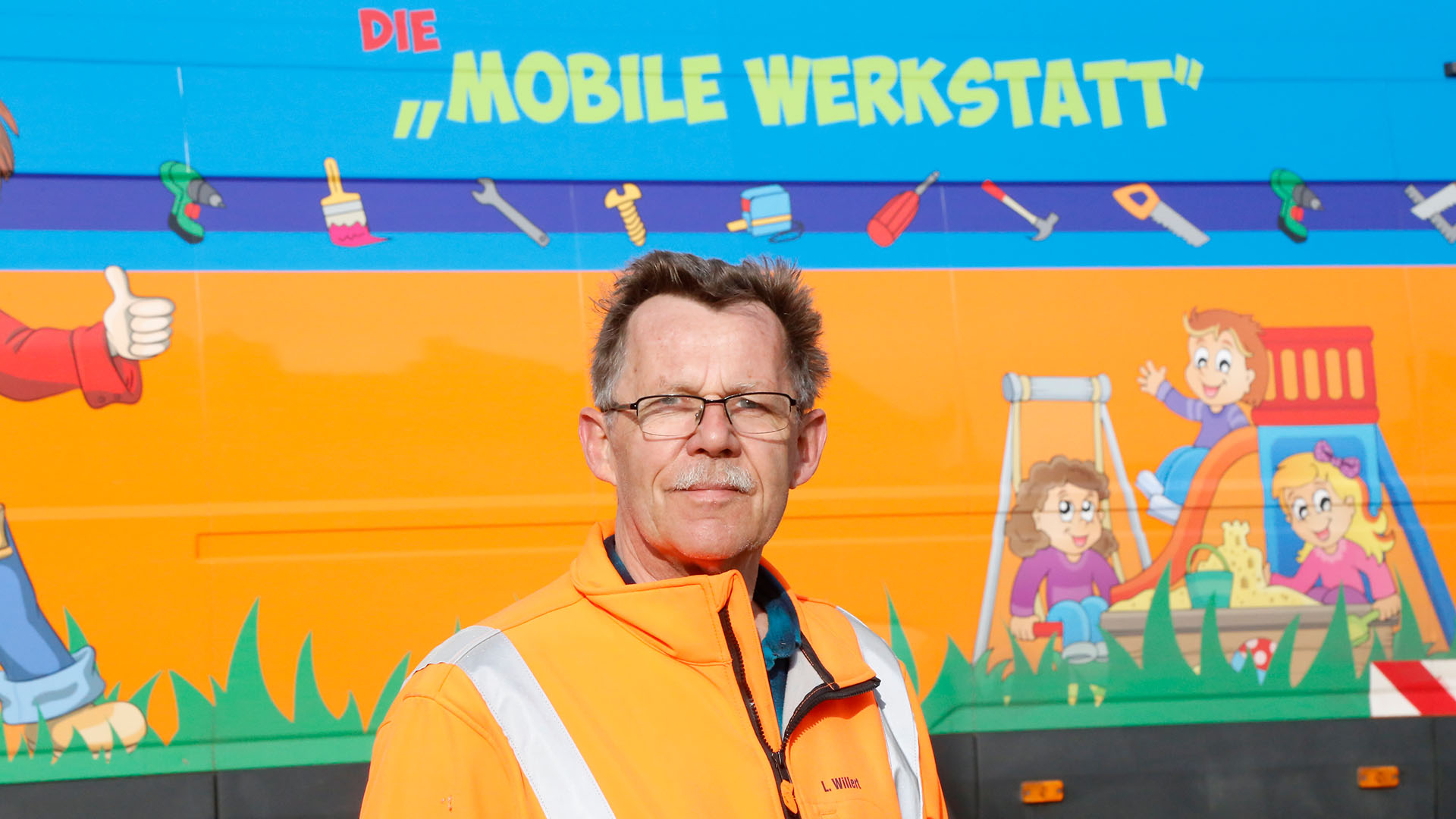 Porträt von Lothar Willert vor dem Wagen der Mobilen Werkstatt