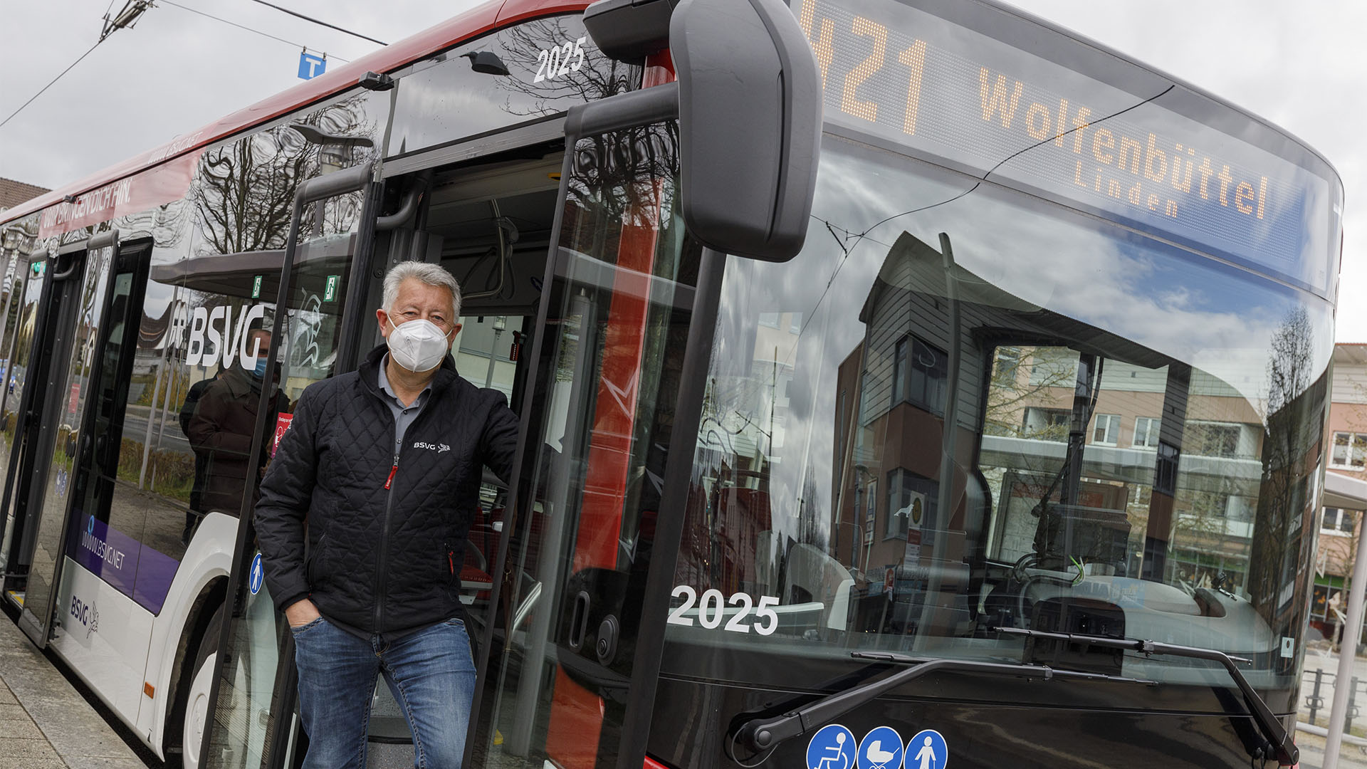 Ein Mann steht neben einem Bus, der im Sichtfenster "421 Wolfenbüttel" anzeigt.