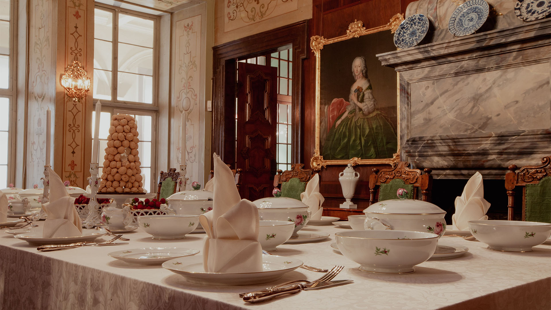 Im historischen Speisezimmer im Schloss hängt ein Ölgemälde an den kunstvoll verzierten Wänden. Die Tafel ist festlich mit Fürstenberger Porzellan - Tellern, Schalen und Terrinen -  eingedeckt.