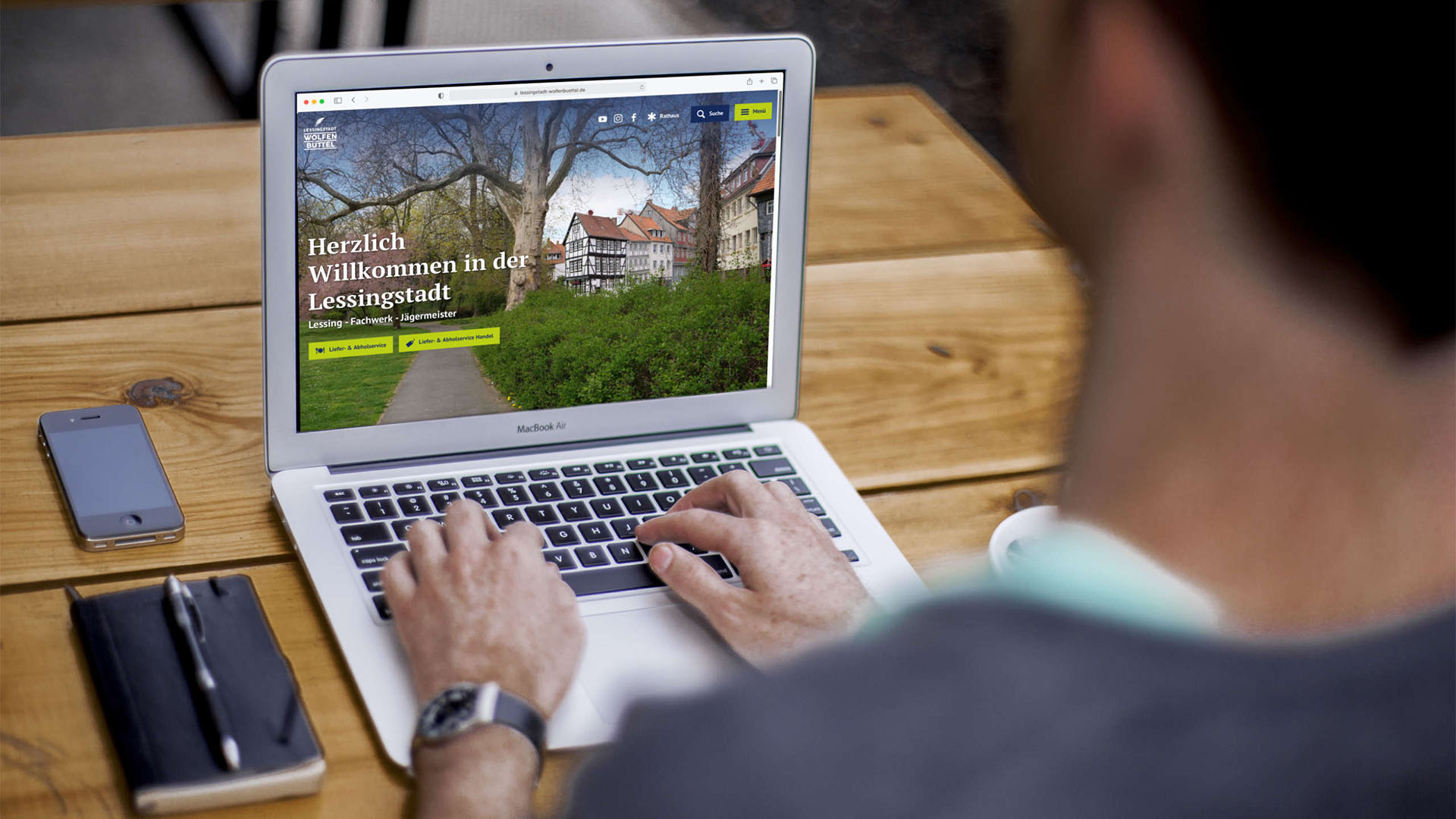 Ein Mann sitzt vor einem Laptop, auf dem die Internetseite der Lessingstadt Wolfenbüttel zu erkennen ist.