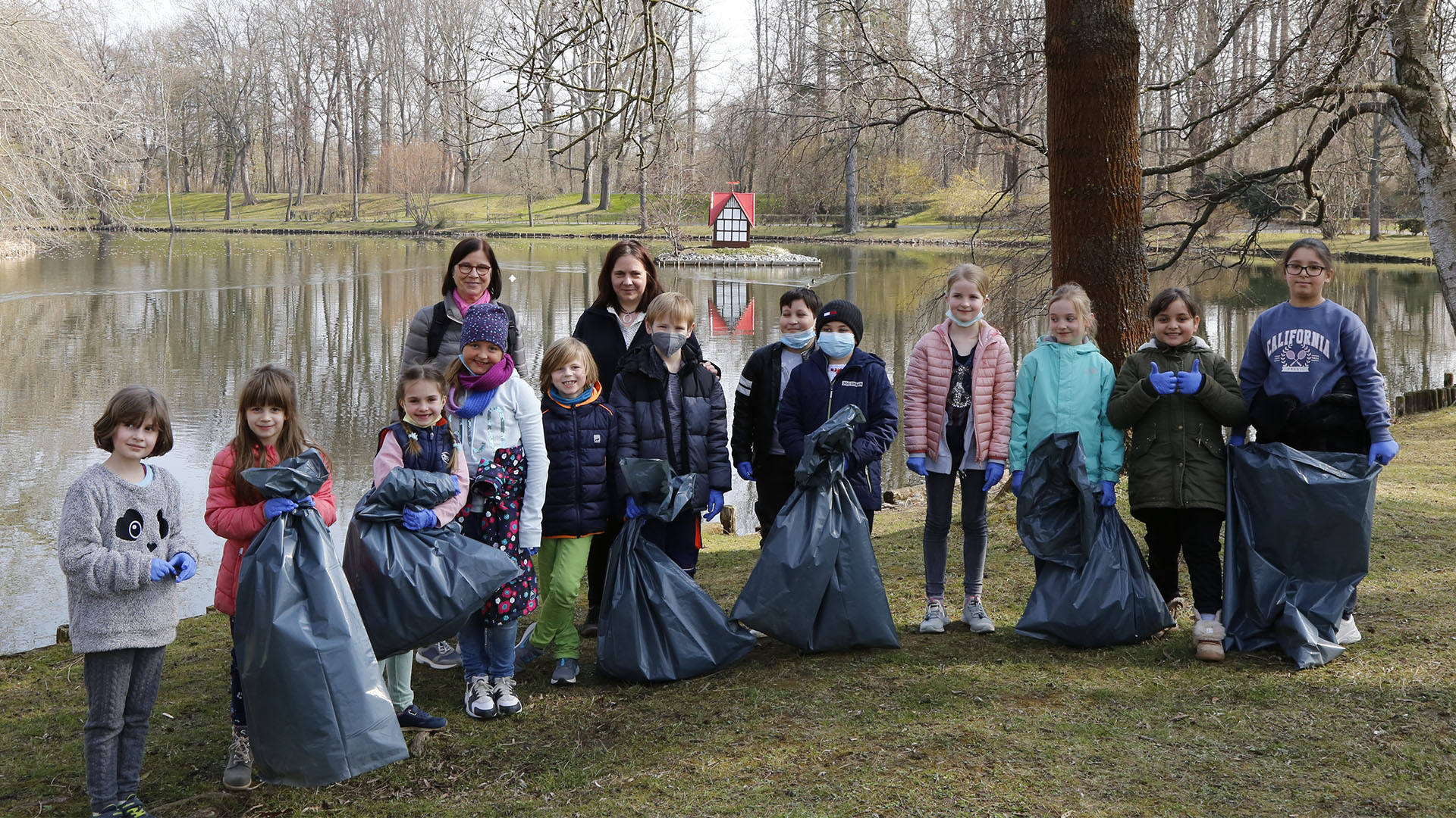 Gruppenbild mit Schülerinnen und Schüler der Grundschule Karlstraße mit prall gefüllten Müllsäcken.