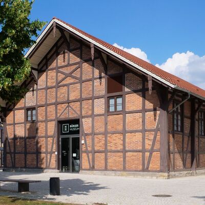 In einem alten Fachwerkhaus mit roten Steinen ist das Bürger Museum der Stadt Wolfenbüttel. Rechts neben dem Gebäude steht ein mehrere Meter hohe Skulptur des Künstlers Markus Lüpertz.