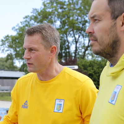 Zwei Männer in gelben Shirts mit Enblem