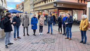 Eine Gruppe Menschen betrachtet Pläne in der Wolfenbütteler Fußgängerzone und diskutiert darüber.