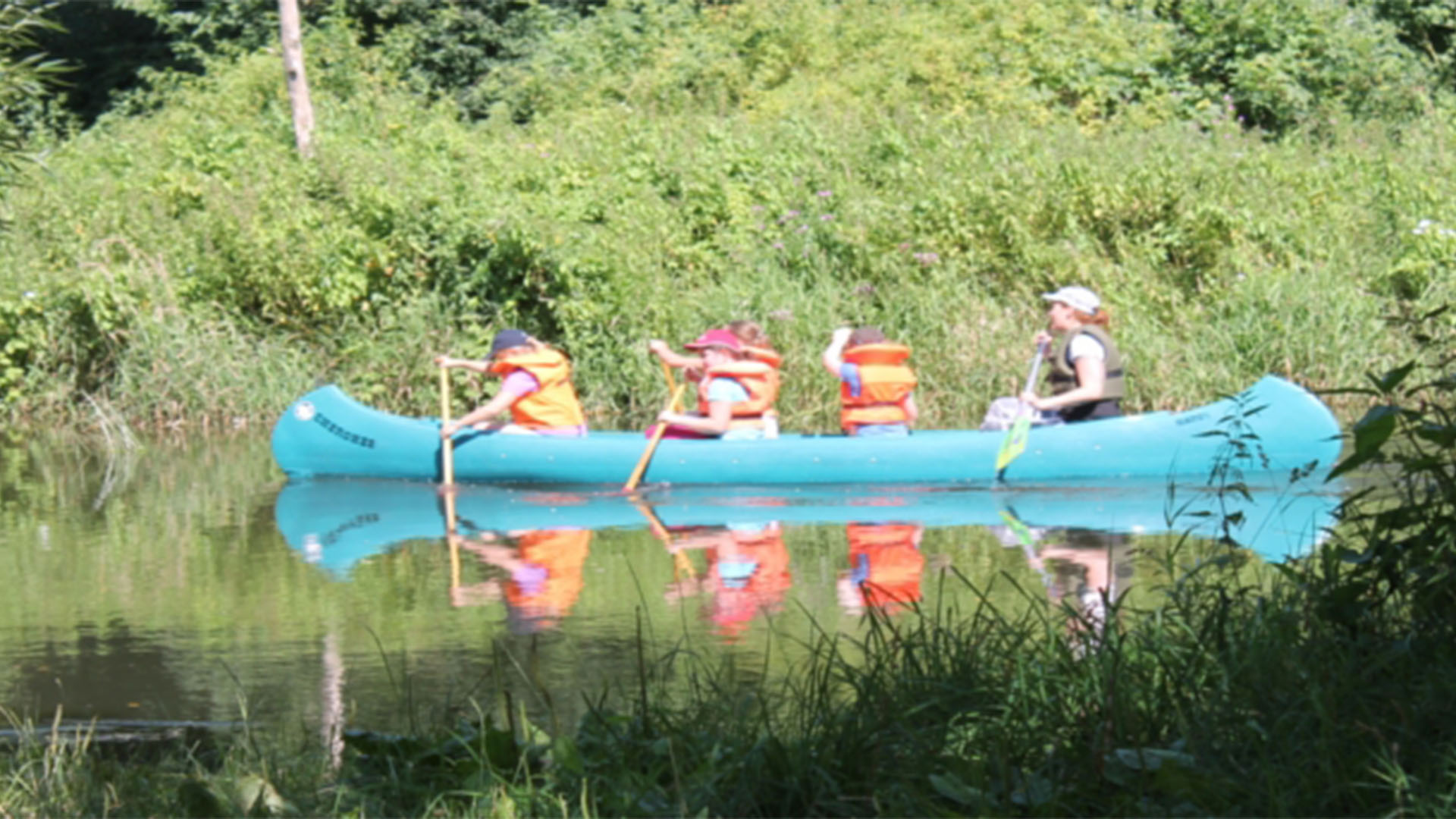 Kinder stzen in einem Kanu und paddeln