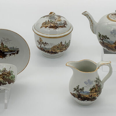Tasse mit Untertasse, Zuckerdose, Milchkännchen und Teekanne in weiß mit Wolfenbütteler Motiven bemalt.