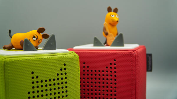 Zwei Tonie-Boxen stehen nebeneinander, auf ihnen zwei Kunststofffiguren - die Maus aus der "Sendung mit der Maus".