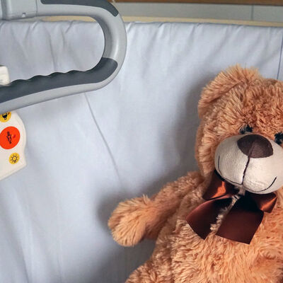 Ein Teddy liegt in einem Krankenbett