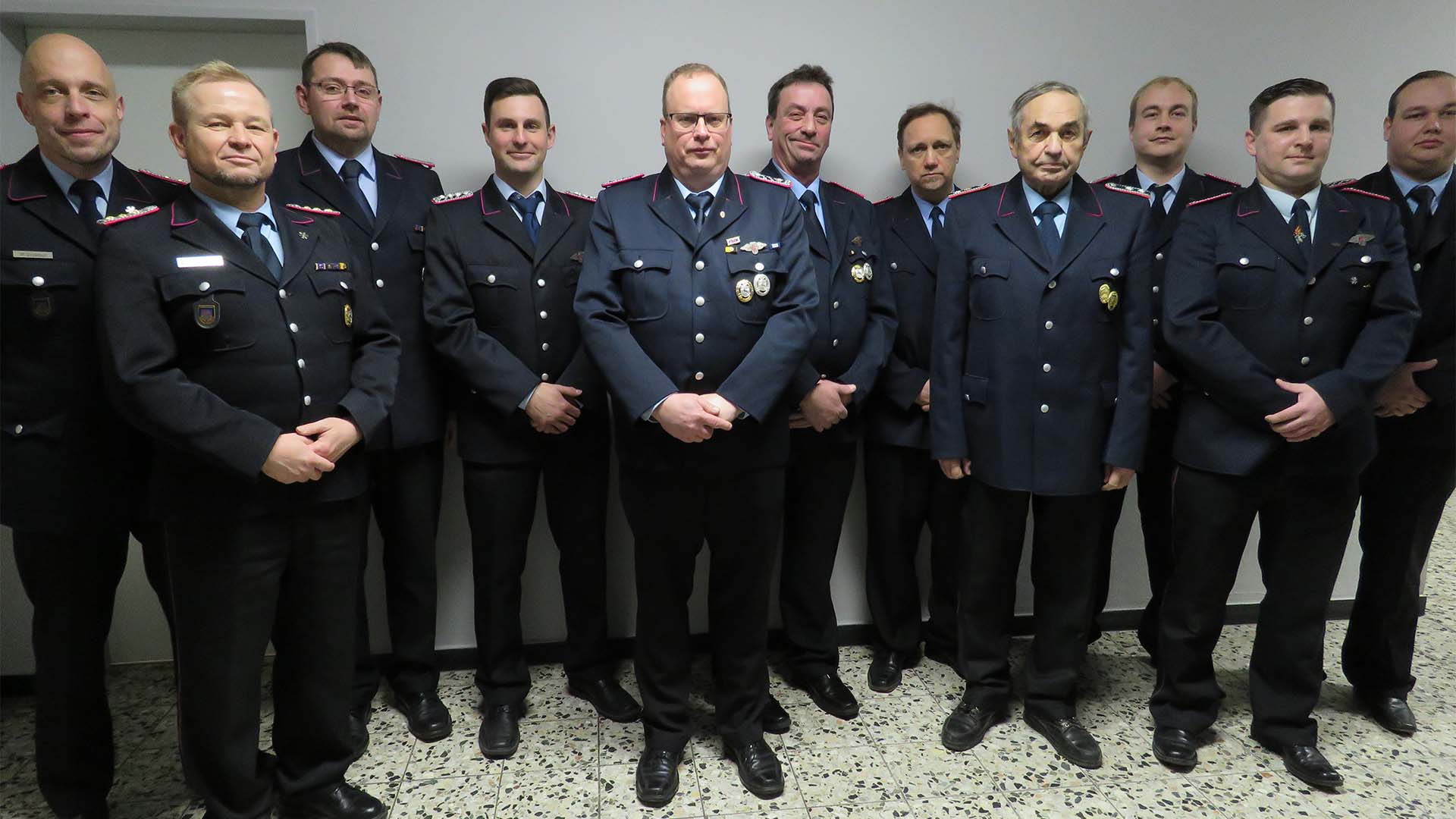 Gruppenbild von elf Männern in Feuerwehr-Uniform.