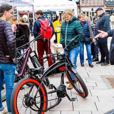 Besucher der Mobilen Welten betravhen Fahrräder an einem Infostand