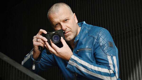 Porträt eines Mannes in Lederjacke und mit Fotoapparat