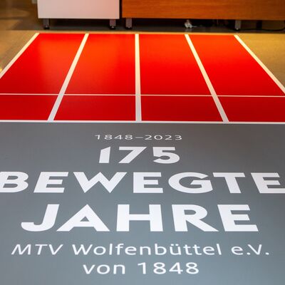 Auf dem Fußboden des Museums steht der Titel 175 bewegte Jahre auf einer roten nachempfundenen Tartanbahn